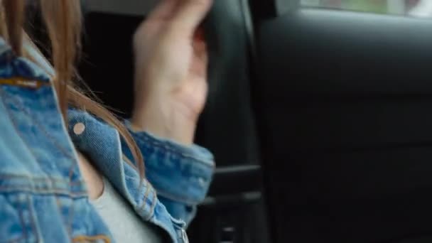 Женская рука пристегивает ремень безопасности автомобиля, сидя внутри автомобиля перед вождением — стоковое видео