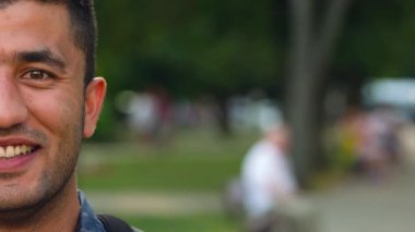 Adam gülümseyen genç bir Arap portresi. Yarım yüz çerçeve içinde. Ağır çekim