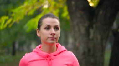 Bir sonbahar parktan günbatımında çalışan kadının kapatın. Ağır çekim