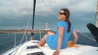 Kadın sarı hat ve mavi elbise yaz sezonu gemiye bir yat lighthouse yakınındaki ocean adlı aittir