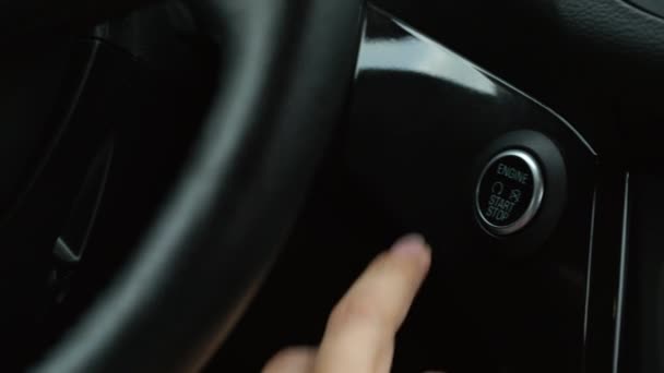 Κοντινό πλάνο γυναικεία δάχτυλο πατώντας ένα κουμπί stop start κινητήρα αυτοκινήτου — Αρχείο Βίντεο