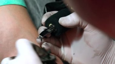 Siyah mürekkep yakın çekim erkek elinde bir dövme çizim işlemi