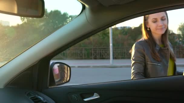 Femme met des sacs à provisions sur un siège d'auto et s'assoit dedans, dans l'intention de conduire loin . — Video