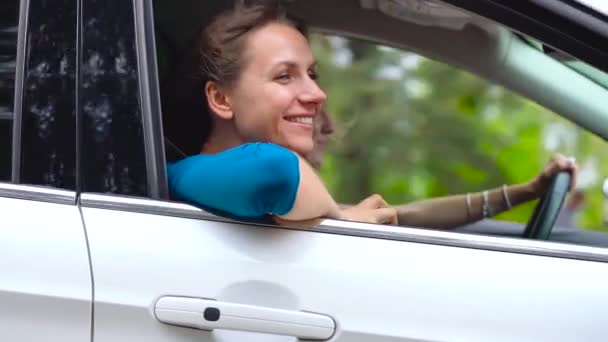 Twee jonge vrouwen rijden in een auto en plezier hebben. Slow motion — Stockvideo