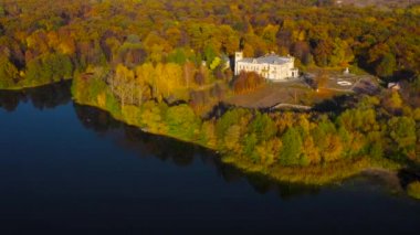Göl, manor ve onun kıyısında parlak sonbahar orman hava görünümünü. Orman göl yüzeyine yansıtılır