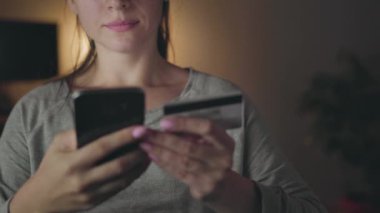 Kadın evde smartphone bir kredi kartı ile online ödeme yapar