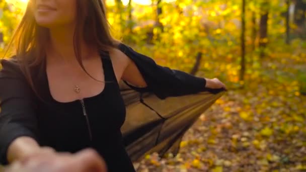 Hermosa chica sostiene la mano de su novio y lo sigue a través del bosque amarillo de otoño. Movimiento lento — Vídeo de stock