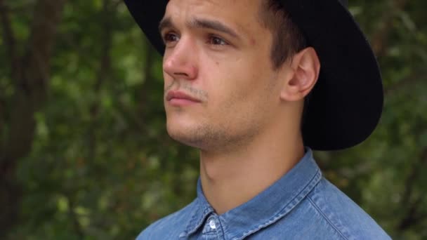 Joven hombre hipster en sombrero riendo, relajado delante de la cámara — Vídeos de Stock