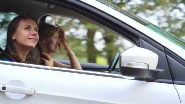 Zwei junge Frauen fahren im Auto und haben Spaß — Stockvideo