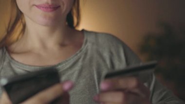 Kadın evde smartphone bir kredi kartı ile online ödeme yapar
