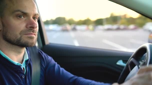 Ο άνθρωπος οδήγηση ενός αυτοκινήτου, ψάχνει για μια θέση να παρκάρει — Αρχείο Βίντεο