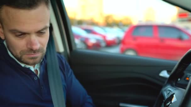 Чоловік керує автомобілем, залишаючи парковку біля торгового центру — стокове відео
