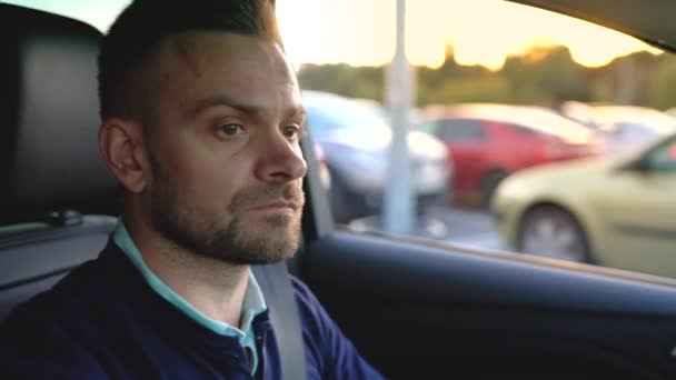 Homem dirigindo um carro, à procura de um lugar para estacionar — Vídeo de Stock