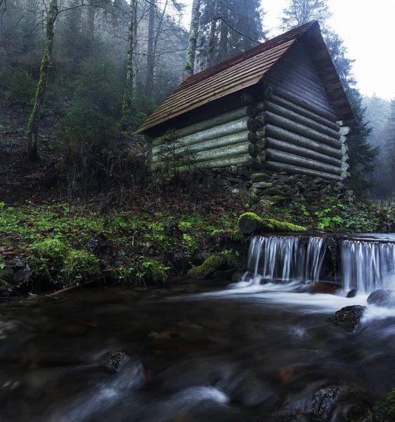 Küçük ev bir dağ nehir kıyısında duruyor. Dağlarda Sisli sabah