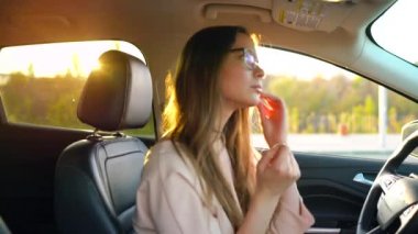 Gözlüklü güzel kız onun kulaklarına kablosuz kulaklık takılı ve sürücü hakkında onun emniyet uzak bir arabaya kemerlerinizi bağlayın