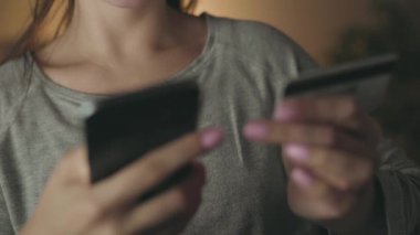 Kadın evde smartphone bir kredi kartı ile online ödeme yapar