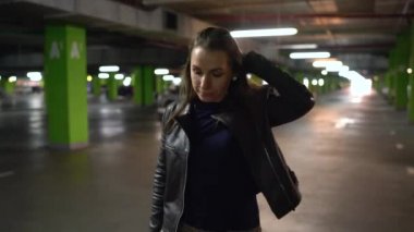 Kadın arabasına gider, kapıyı açar ve içinde oturur