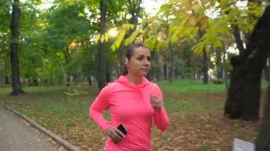 Bir sonbahar parktan günbatımında çalışan kadının kapatın. Ağır çekim