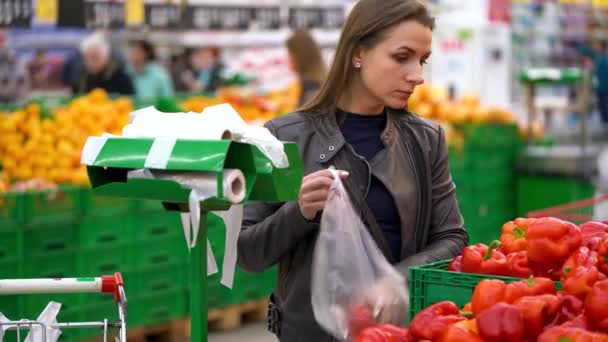 女性がスーパーに赤ピーマンを選択します。 — ストック動画