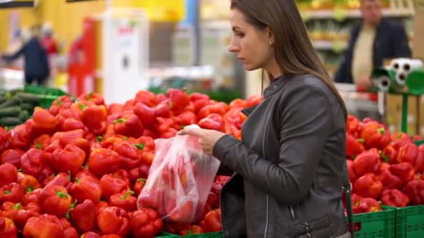 Mujer elige pimiento rojo en el supermercado — Vídeo de stock