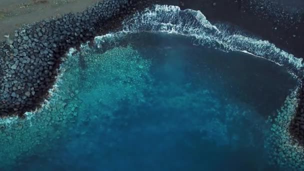 Vista superior de una playa volcánica negra desierta. Costa de la isla de Tenerife. Imágenes aéreas de drones de olas marinas que llegan a la orilla — Vídeo de stock