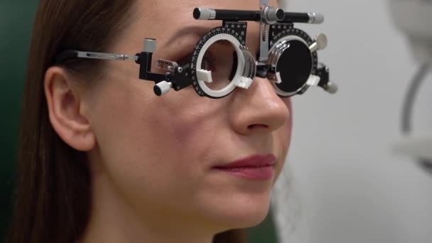 Femme à la réception d'un ophtalmologiste. Examen des yeux et sélection des verres de lunettes — Video