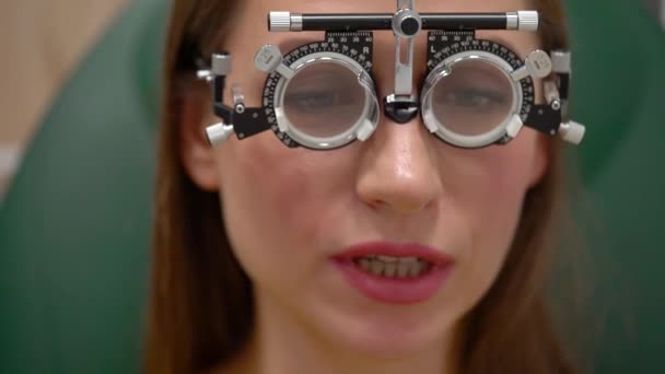 Femme à la réception d'un ophtalmologiste. Examen des yeux et sélection des verres de lunettes — Video