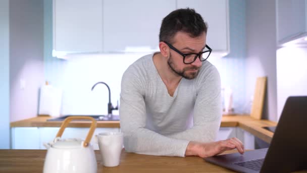 Homem Barbudo Tomando Café Manhã Cozinha Usando Laptop Mesmo Tempo — Vídeo de Stock