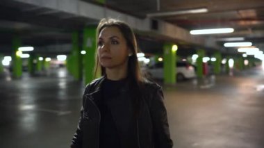 Kadın arabasına gider, kapıyı açar ve içinde oturur