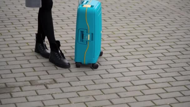 Blond meisje rolt een koffer in de buurt van de luchthaven terminal — Stockvideo