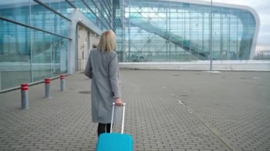 Sarışın kız terminal - arka görünümünden yakınındaki bir çanta alır