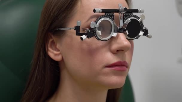 Femme à la réception d'un ophtalmologiste. Examen des yeux et sélection des verres de lunettes — Video