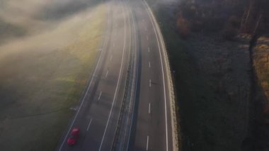 Havadan görünümü yolun üzerinde araba hareket ediyor. Yolun sisin içinde kefen