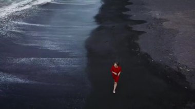 Siyah kum ile sahilde yürüyüş kırmızı elbiseli bir kız hava görünümünü. Tenerife, Kanarya Adaları, İspanya