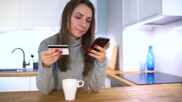 女性は、クレジット カードとスマート フォンで自宅のオンライン決済になります — ストック動画