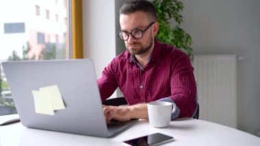 Ev ve iletişim kavramı - office evde oturan ve bir dizüstü bilgisayar üzerinde çalışan gözlüklü adam