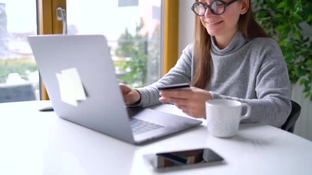 Kobieta sprawia, że płatności online w domu z karty kredytowej i laptopa — Wideo stockowe