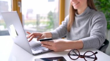 Kadın evde laptop bir kredi kartı ile online ödeme yapar