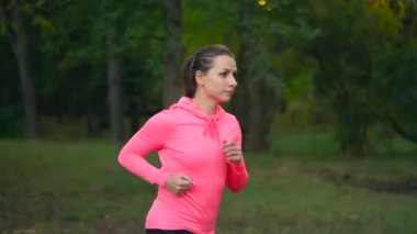 Bir sonbahar parktan günbatımında çalışan kadının kapatın. Ağır çekim