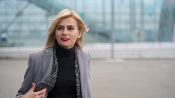 Szőke lány tekercs egy bőröndöt a repülőtér terminál — Stock videók