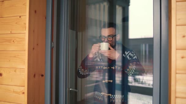 Hombre Barbudo Bebiendo Café Cerca Ventana Mirando Través Del Vidrio — Vídeo de stock