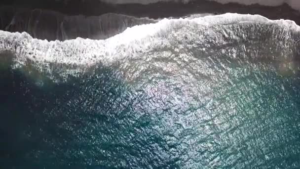 Bovenaanzicht van een verlaten zwarte vulkanische strand. Kust van het eiland Tenerife. Luchtfoto drone beelden van golven van de zee oever bereiken — Stockvideo