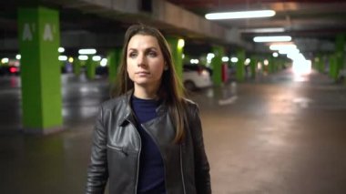 Kadın arabasına gider, kapıyı açar ve içinde oturur