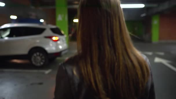 Nő megy a kocsiját, kinyitja az ajtót, és leül — Stock videók