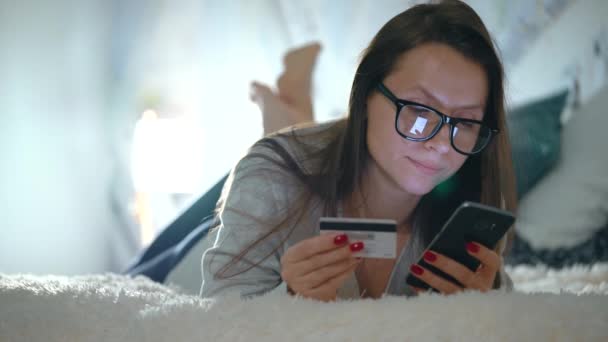 Frau macht Online-Zahlung zu Hause mit Kreditkarte und Smartphone — Stockvideo