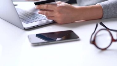 Kadın evde laptop bir kredi kartı ile online ödeme yapar. Görünümü kapatın