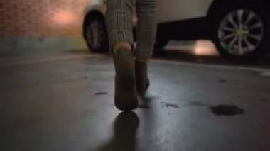 Kadın arabasına gider, kapıyı açar ve içinde oturur