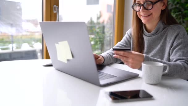 Femme effectue le paiement en ligne à la maison avec une carte de crédit et un ordinateur portable — Video