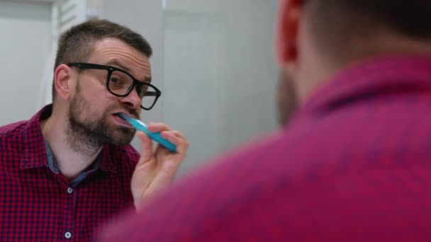 Hombre barbudo lavándose los dientes en un baño por la mañana. Higiene matinal . — Vídeos de Stock