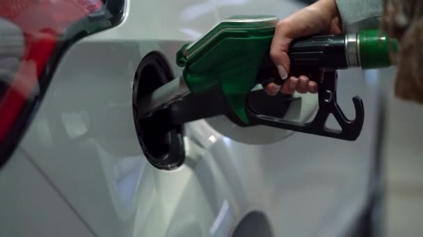 Жінка заповнює бензин у свою машину на АЗС крупним планом — стокове відео